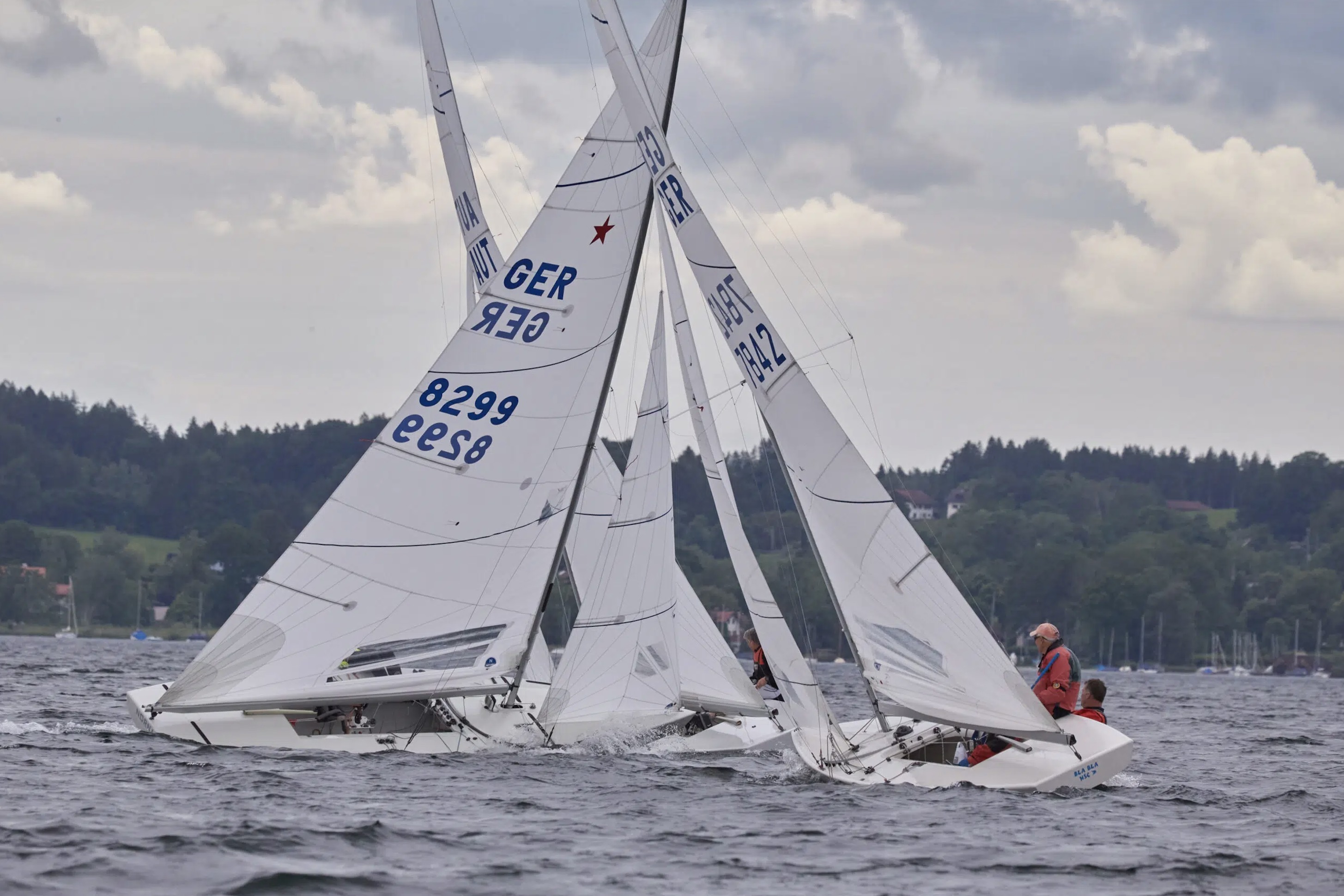 Kreuzende Starboote. GER 8299 (links) segelt auf Steuerbordbug vor GER 7842 (rechts) her, der auf Backbordbug läuft.